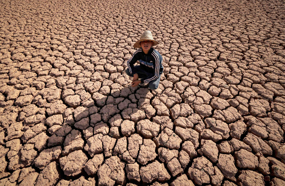 A child crouches over cracked earth at al- massira Dam in Ouled Essi masseoud village amid morocco’s worst drought in at least four decades. (AFP) 