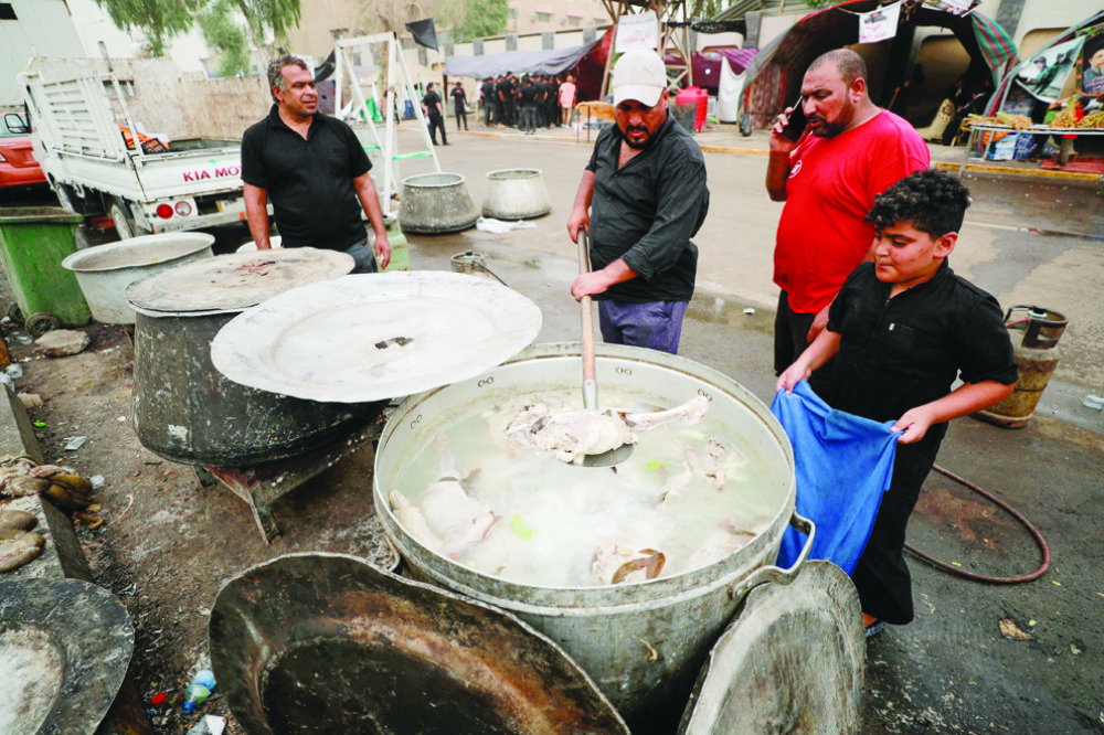 Iraqi volunteers prepare food for supporters of Moqtada Sadr as they continue to protest outside the parliament building in the Green Zone of Baghdad. (File/AFP)