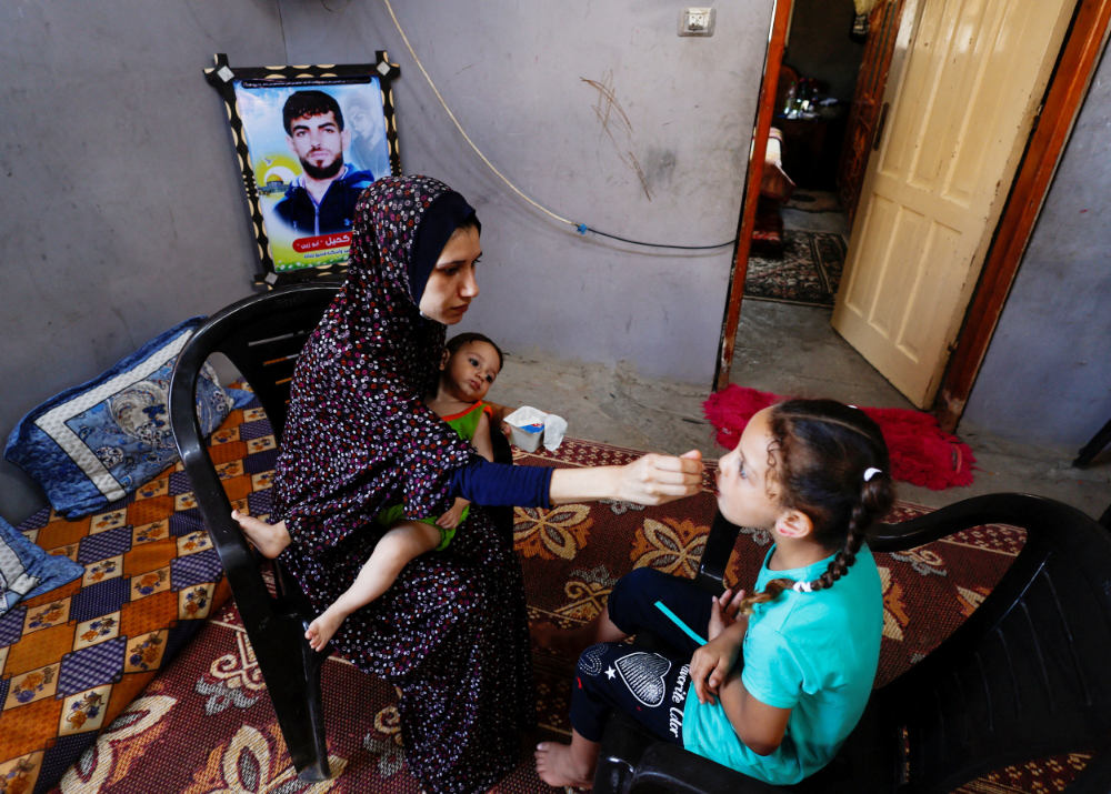 Wife of Shadi Khail, who was killed in the recent Israel-Gaza fighting, feeds her children at her home in Gaza City August 16, 2022. (REUTERS)
