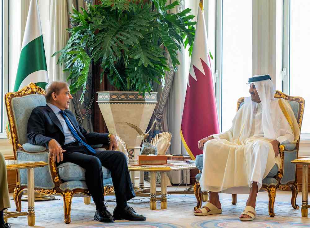 Qatar’s Emir Sheikh Tamim bin Hamad meets Pakistan Prime Minister Shahbaz Sharif upon his arrival in Doha on Aug. 24, 2022. (AFP/Qatar Amiri Diwan)