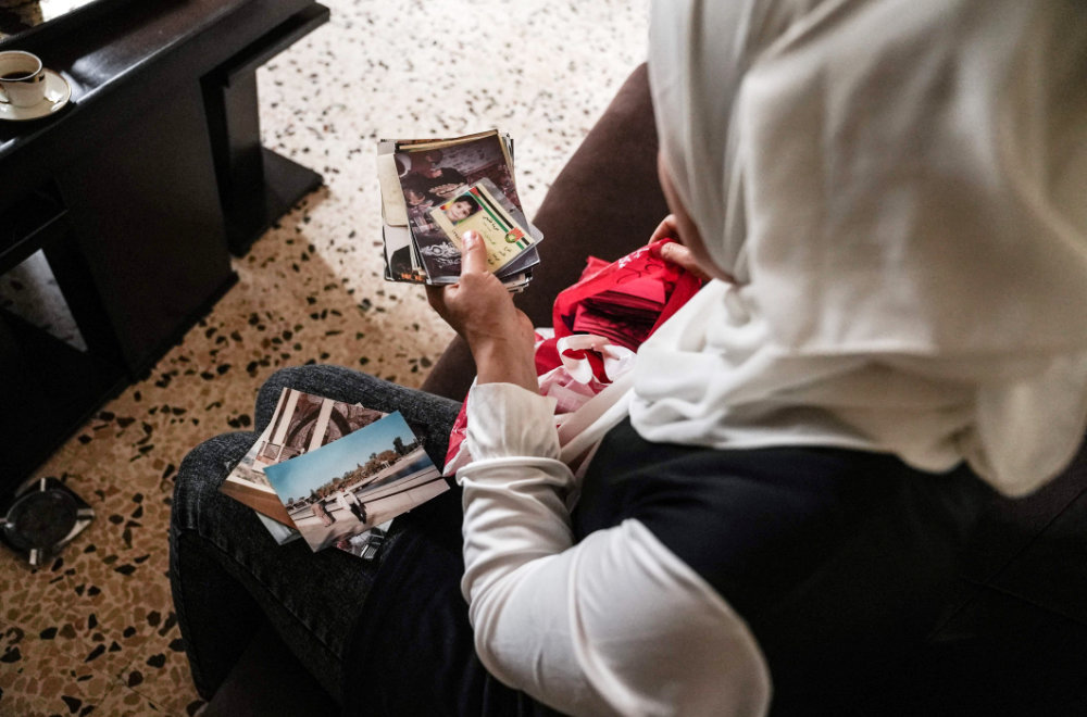 Syrian refugee Ramya al-Sous inspects her family documents at her apartment in Lebanon's Bekaa Valley, on June 13, 2022. (AFP)