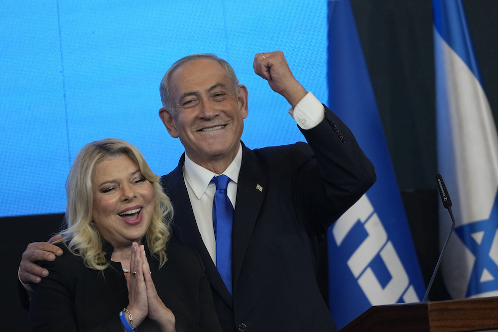 Former Israeli Prime Minister and the head of Likud party, Benjamin Netanyahu and his wife Sara gesture after first exit poll results for the Israeli Parliamentary election at his party's headquarters in Jerusalem. (AP)