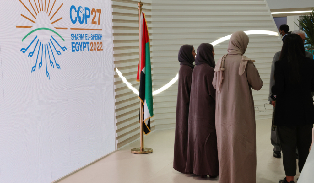 Muslim women walk past the COP27 sign at the Sharm el-Sheikh International Convention Centre, in Egypt's Red Sea resort city of the same name, during the COP27 climate conference on Novemeber 15, 2022. (AFP)