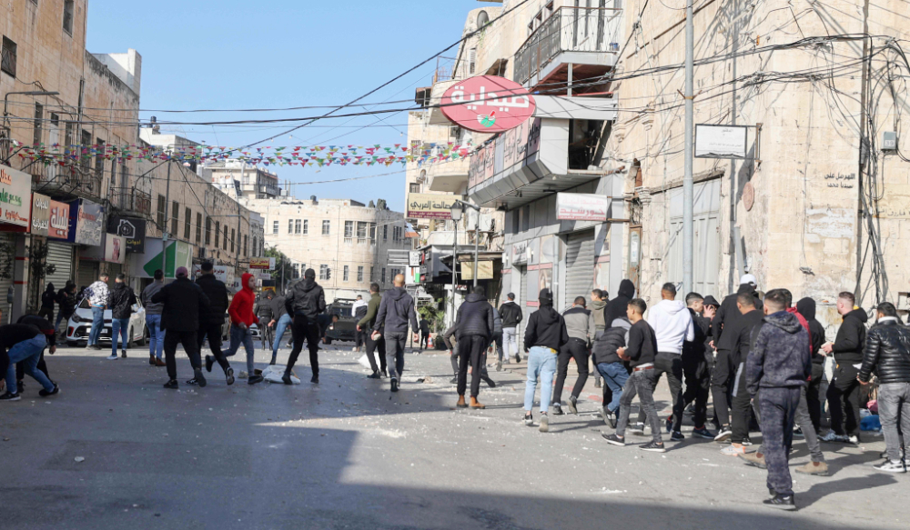 Palestinian protesters rally amid clashes with Israeli security forces deploying during a raid in the old city of Nablus, in the occupied West Bank, on December 30, 2022. (AFP)