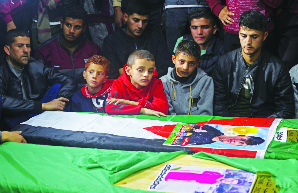 Mourners gather around the coffins of four Palestinian migrants during their funeral at a mosque in Rafah in the southern Gaza Strip. (AFP file photo)