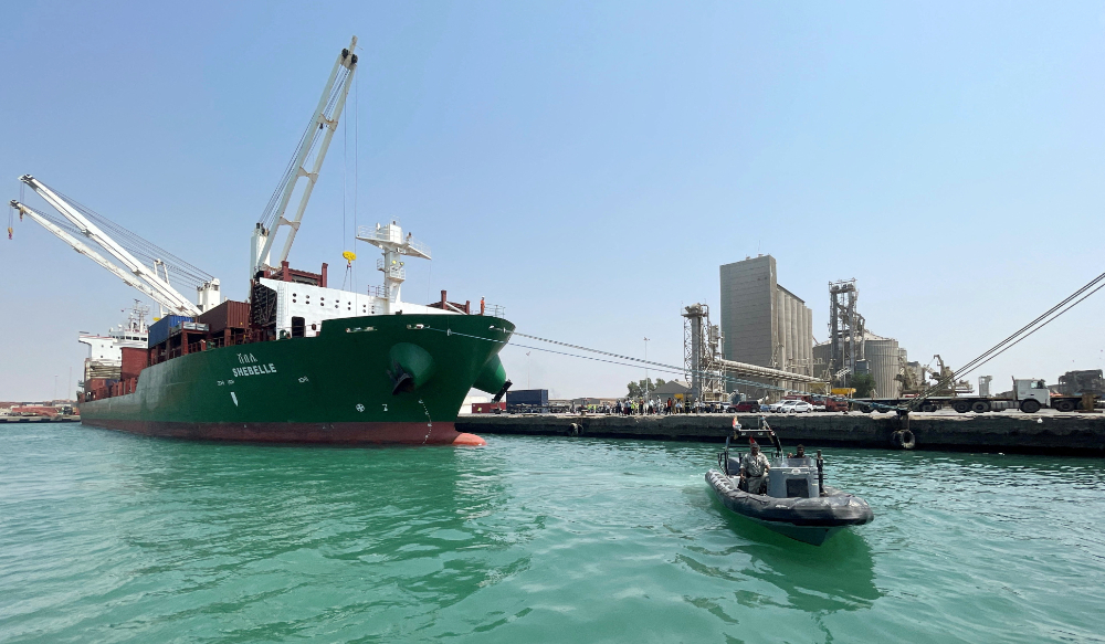 A coastguard boat sails past a commercial container ship docked at the Houthi-held Red Sea port of Hodeidah, as a container ship carrying general commercial goods docked at the port for the first time since at least 2016, in Hodeidah, Yemen February 25, 2023. (REUTERS)