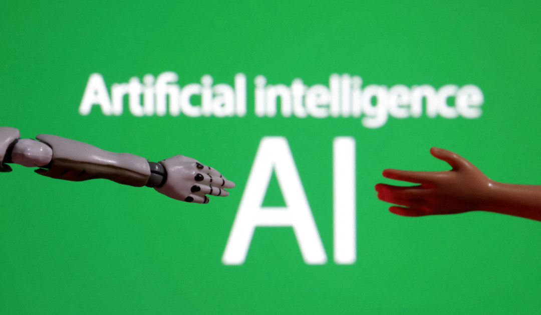 Words reading "Artificial intelligence AI", miniature of robot and toy hand are pictured in this illustration. (REUTERS)