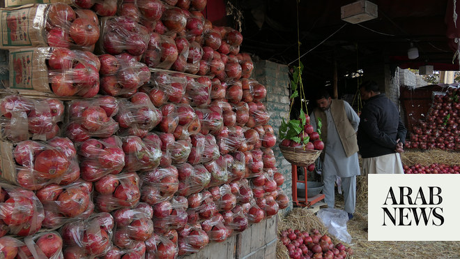 Pakistani shoppers purchase vegetables from a stall inside a