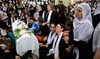 Druze women mourn by a coffin during a funeral of a person killed in a rocket strike from Lebanon a day earlier in Golan Heights