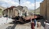 Railway workers clear the wreckage of a collapsed railway bridge the morning after a blast by separatist militants at Kolpur.