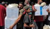 People receive humanitarian aid packages provided by UNRWA from a warehouse in central Gaza City on August 27, 2024. (AFP)