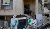 Palestinian children stand amid the destruction caused by an Israeli raid in the Nur Shams camp near Tulkarem