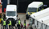 Migrants picked up at sea attempting to cross the English Channel from France are escorted ashore after disembarking.