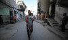 A civil defence worker carries a girl at a school site, which was sheltering displaced people,after it was hit by Israeli strike