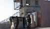 Taliban members stand guard at an entrance of the Panjwai district police headquarters in Kandahar province. (File/AFP)