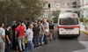 Lebanese Red Cross ambulance passes next of the families of victims who were injured on Monday by their exploding handheld pager