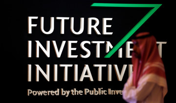 A Saudi man walks past the sign of the Future Investment Initiative during the investment conference in Riyadh. (REUTERS)