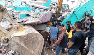 Rescuers search for survivors at a collapsed building in Mamuju city on January 15, 2021, after a 6.2-magnitude earthquake rocked Indonesia's Sulawesi island. (AFP / Mawardi)