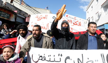 Demonstrators carry signs during an anti-government protest in Tunis , Tunisia January 26, 2021. (Reuters)