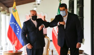 Handout picture released by Venezuelan Presidency showing Venezuela's President Nicolas Maduro (R) bumping elbows with the Foreign Minister of the Islamic Republic of Iran, Javad Zarif (L) at Miraflores Palace in Caracas, on November 5, 2020. (AFP/File Photo)