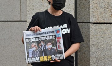 A supporter of Hong Kong's pro-democracy Apple Daily newspaper holds up a copy of the newspaper during a protest outside court in Hong Kong. (AFP)