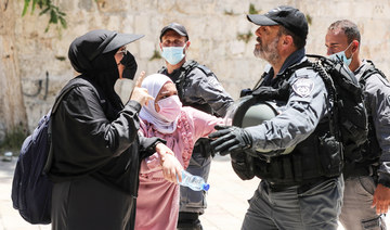 Palestinian women argue with an Israeli security force member after brief clashes erupted between Israeli police and Palestinians at al-Aqsa Mosque in Jerusalem's Old City, July 18, 2021. (REUTERS)