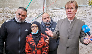 Fatima Salem (C) looks on as Sven Kuhn von Burgsdorff, head of the European Union's mission to the West Bank and Gaza Strip (R) speaks to the media during his visit to her home in Sheikh Jarrah on December 20, 2021. (AFP)