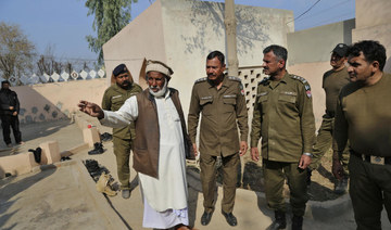Mian Mohammad Ramzan the mosque custodian gestures as he briefs police officers regarding the stoning to death of Mushtaq Ahmed in Tulamba, eastern Pakistan, Sunday, Feb. 13, 2022. (AP)