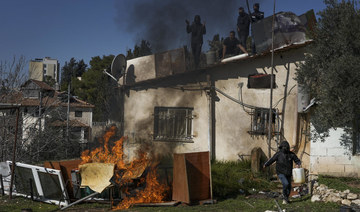 Palestinian men stand on the roof of a house as Israeli police prepare to evict a family, in the flashpoint east Jerusalem neighborhood of Sheikh Jarrah in Jan. (AP)