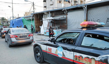 People walk past Lebanese police patrol cars in Souk Sabra in the southern suburbs of the Lebanon's capital Beirut. (AFP file photo)