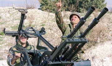 A Lebanese soldier points to the sky as an Israeli warplane passes through Lebanon's airspace near the southern port of Sidon. 