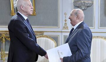 Sadok Belaid submitting a draft of the new constitution to President Kais Saied (L) in Tunis. (AFP file photo)