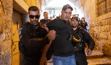 AFP photojournalist Ahmed Gharabli is taken out by Israeli police officers from Jerusalem's old city, on August 7, 2022. (AFP)