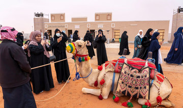 Saudi women take photos of camels at the King Abdulaziz Camel Festival which kicked off in early December. (Supplied/Camel Club)