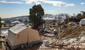 People walk by collapsed houses in Buyuknacar village in Kahramanmaras, Turkey, Wednesday, Feb. 15, 2023. (AP)