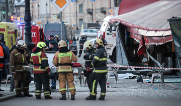 Russian Emergency Situations Ministry stand at the side of an explosion at a cafe in St. Petersburg, Russia, Sunday.