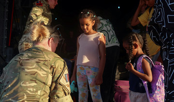 Sudanese citizens with UK citizenship wait to board a British military aircraft before being processed for evacuation.