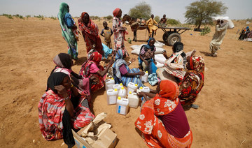 Sudanese refugees, who have fled the violence in their country, sit after they received the food rations from World Food Program