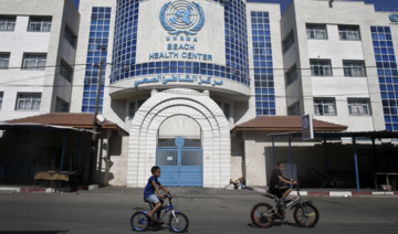 Children ride their bicycles in front of a health center run by the United Nations Relief and Works Agency in Gaza