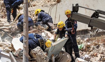 Civil defense first responders search through rubble at the scene of a collapsed 13-storey-building in the Sidi Bishr district.