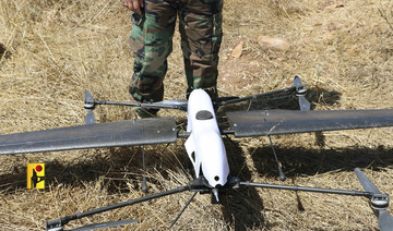 A Hezbollah fighter stands next to an Israeli drone in southern Lebanon on Monday, June 26, 2023. (AP)