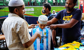 A young fan of Argentina tries a jersey from a street shop ahead of the FIFA World Cup, in Dhaka, Bangladesh, Nov. 16, 2022.  