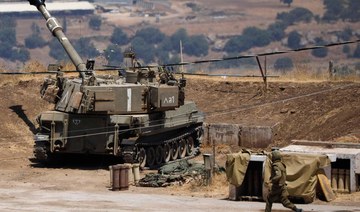 A soldier runs near an Israeli army vehicle on the outskirts of Kiryat Shmona near Israel's border with Lebanon. 