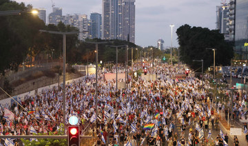 Demonstrators wave flags as they protest the Israeli government's judicial overhaul plan in Tel Aviv on July 29, 2023. (AFP)