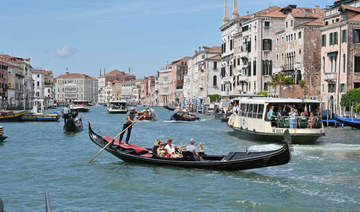 A view taken on July 31, 2023 shows tourists taking a Gondola ride across the Grand Canal in Venice. (AFP)