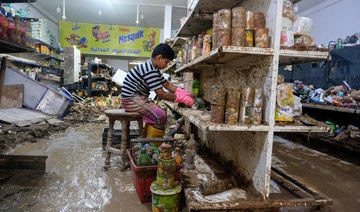 A boy cleans merchandise inside a damaged grocery store affected by fatal floods, in Derna, Libya, September 28, 2023. (Reuters)