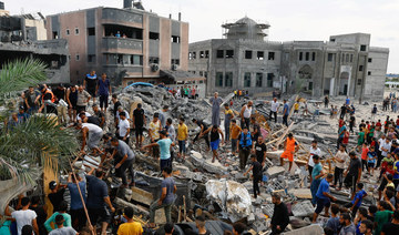 Palestinians walk among the rubble of a building destroyed in Israeli strikes, in the southern Gaza Strip October 9, 2023. 