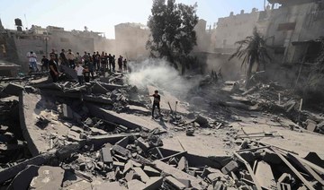 Palestinians search for survivors and the bodies in the rubble of buildings destroyed during Israeli bombardment, in Khan Yunis 