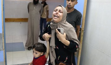 A Palestinian woman reacts as she arrives with her child to the Nasser hospital following an Israeli strike, in Khan Yunis.