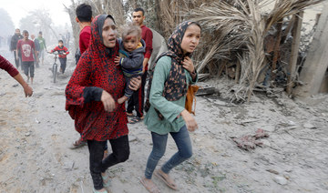 Palestinians leave the site of an Israeli air strike on a house in Khan Younis, in the southern Gaza Strip November 22, 2023. 